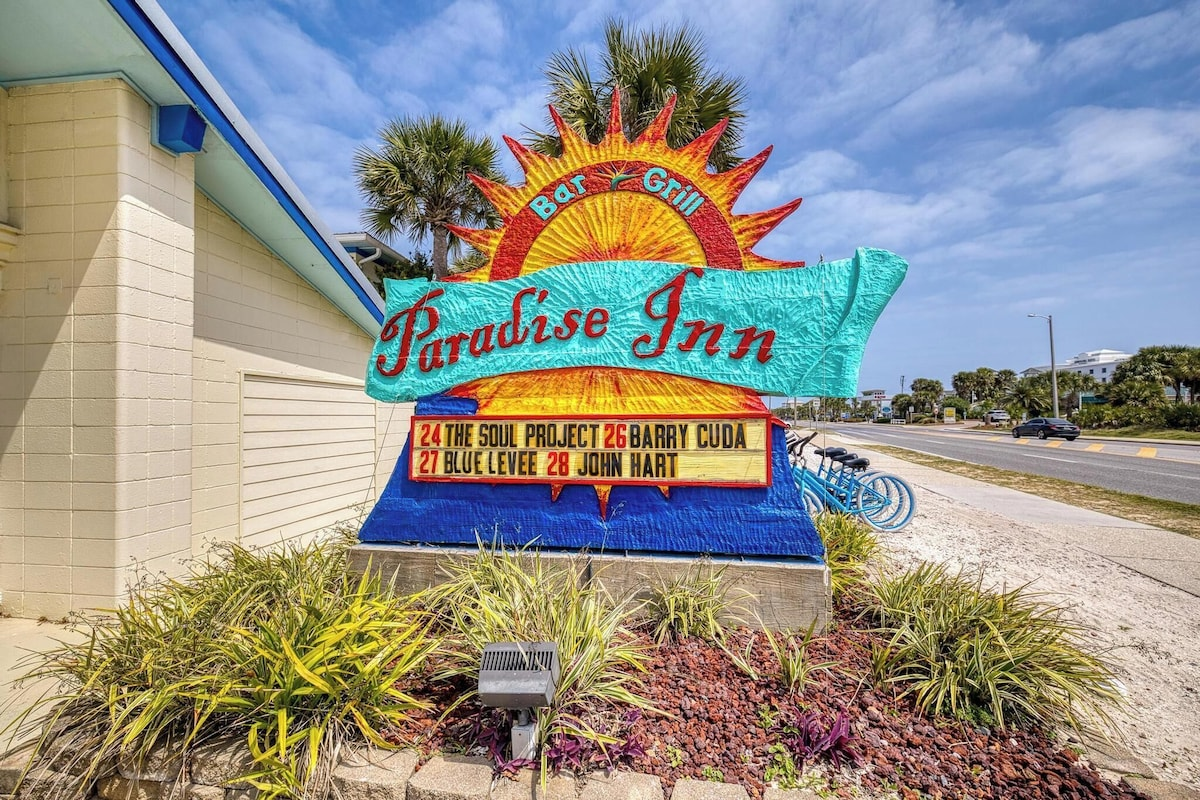 Paradise Inn roadside sign near the beach.